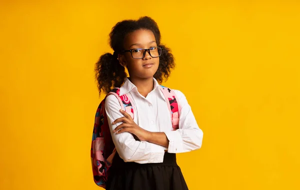 Seria negra escuela chica cruce manos posando sobre amarillo fondo — Foto de Stock