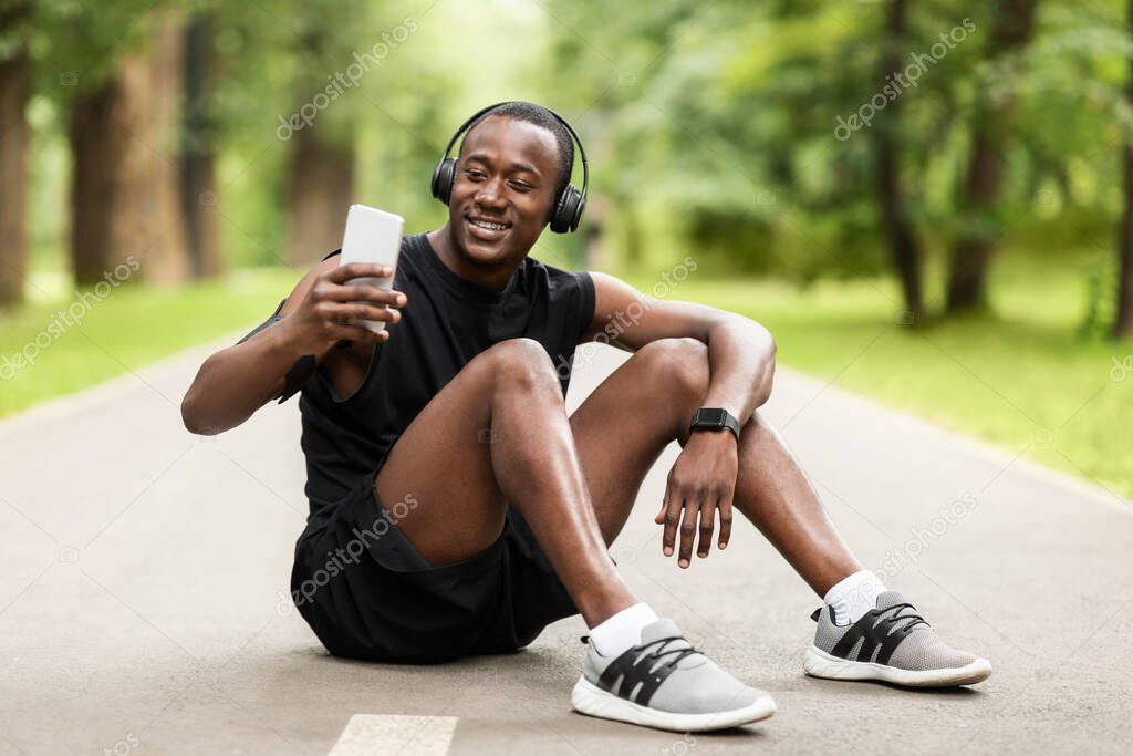 Happy african sportsman taking selfie during break