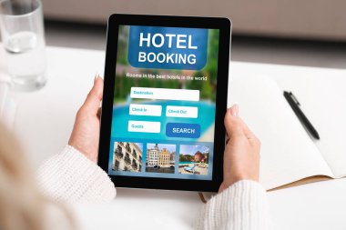 İş kadını otel rezervasyonunu çevrimiçi yapıyor Tablet kullanarak içeride oturuyor, kırpılmış