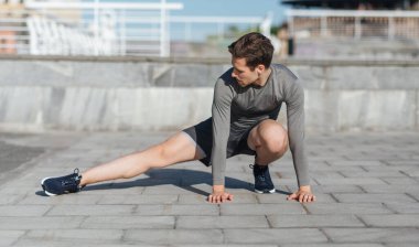 Sağlıklı yaşam tarzı, ısınma ve koşu. Antrenmana başlamadan önce egzersiz yapan adam.