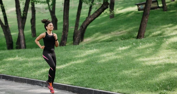 Corredor de la mañana corriendo en un parque. Chica con auriculares, rastreador de fitness —  Fotos de Stock