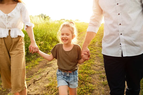 Glückliche Eltern und Mädchen spazieren gemeinsam im Sommer draußen — Stockfoto