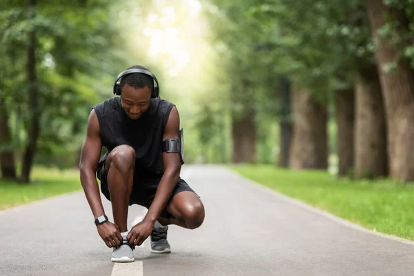 Afrikaner bindet Schnürsenkel an Turnschuhe, bevor er joggt — Stockfoto