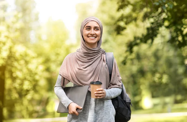 Feliz mujer de negocios musulmana caminando por el parque, bebiendo café — Foto de Stock