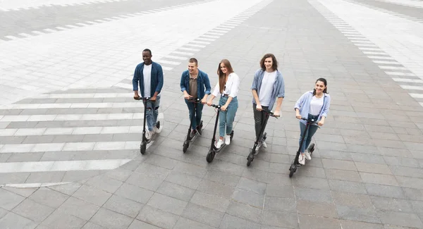 Cinco amigos que tienen un buen paseo en scooters de patada eléctrica — Foto de Stock