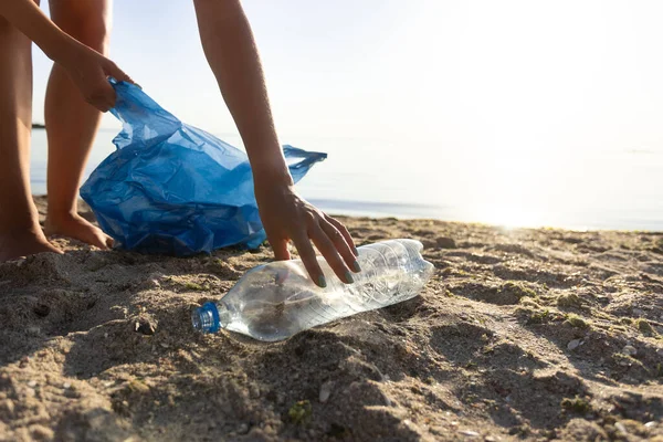 义工在受污染的海滩上捡塑料瓶， — 图库照片