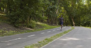 Aktif siyahi sporcu eğitimi, şehir parkında koşmak.