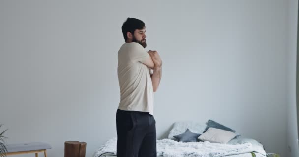 Hombre joven calentando, estirando las manos en casa — Vídeos de Stock