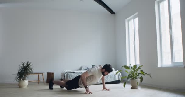 Jeune homme pratiquant l'exercice burpee à la maison — Video