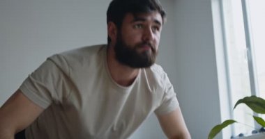 Evde çalışan genç adamın portresi, yakın çekim.