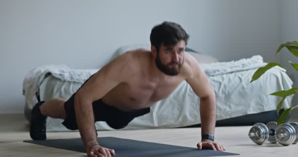 Muscular man doing push ups, exercising at home — Stock Video