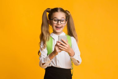 Heyecanlı İlköğretim Öğrencisi Kız Akıllı Telefonla Ödev Yapıyor, Stüdyo Çekimi