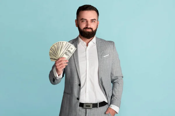 Alcanzar el éxito. Propietario de negocios adinerado mostrando dinero americano sobre fondo azul —  Fotos de Stock