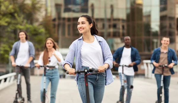 Szczęśliwi studenci jeżdżący na elektrycznych hulajnogach — Zdjęcie stockowe