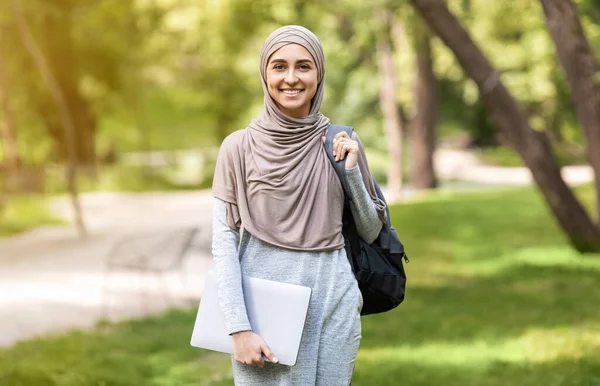 Atractiva mujer musulmana con portátil posando en el parque — Foto de Stock