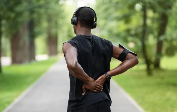 Vista trasera del hombre negro en ropa deportiva tocando la espalda lesionada — Foto de Stock