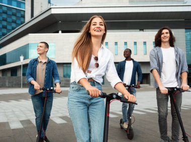 Arkadaşların motorlu scooterlara binerken iyi vakit geçiriyorlar.
