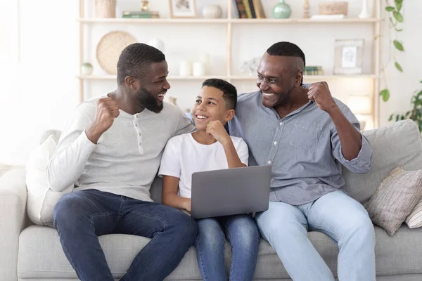 Pai negro feliz filho e avô celebrando o sucesso com laptop em casa — Fotografia de Stock