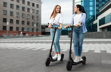 Şehirde motorlu scooter kullanan arkadaşlar.