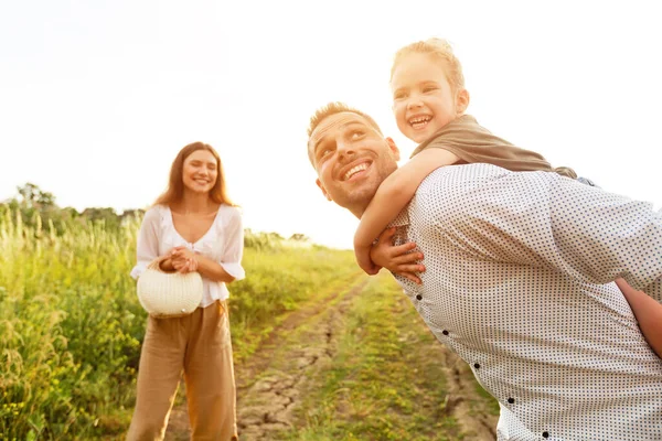 Ung förälder ger piggyback rida till sitt barn — Stockfoto