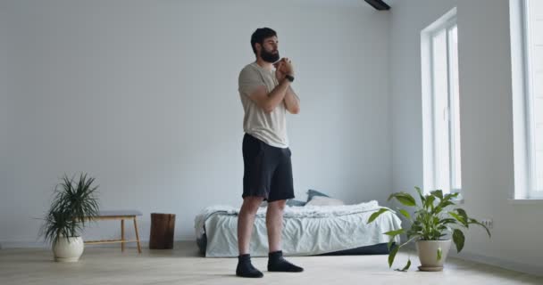 Hombre milenario entrenando en casa, ejercitando las manos — Vídeo de stock