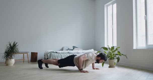 A fiatalember fekvőtámaszt gyakorol otthon. — Stock videók