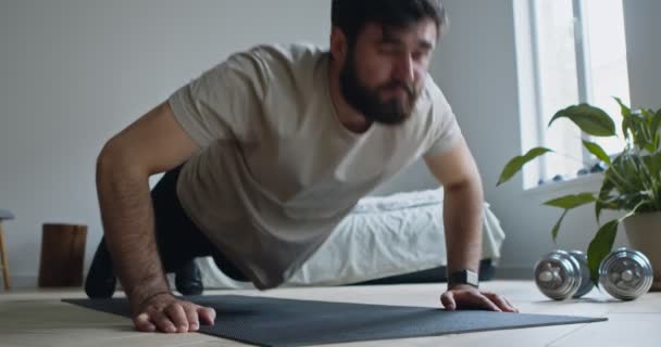 Närbild av skäggiga killen gör armhävningar hemma — Stockvideo