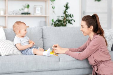 Ebeveynlik kavramı. Mutlu anne evde sevimli oğluyla oynuyor.
