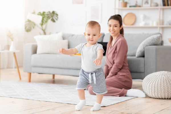 Eerste stappen. Schattige lachende baby jongen die thuis leert lopen, — Stockfoto