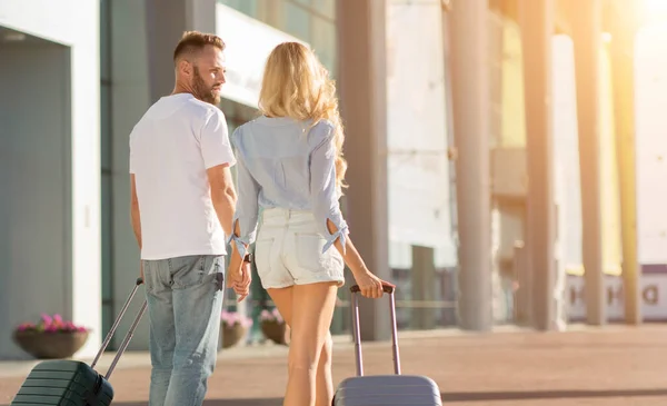 Coppia felice a piedi in aeroporto con valige — Foto Stock