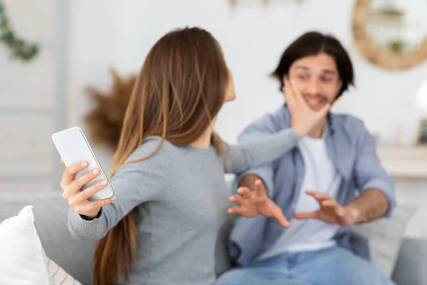 Femme furieuse vérifiant son téléphone mari devant lui — Photo