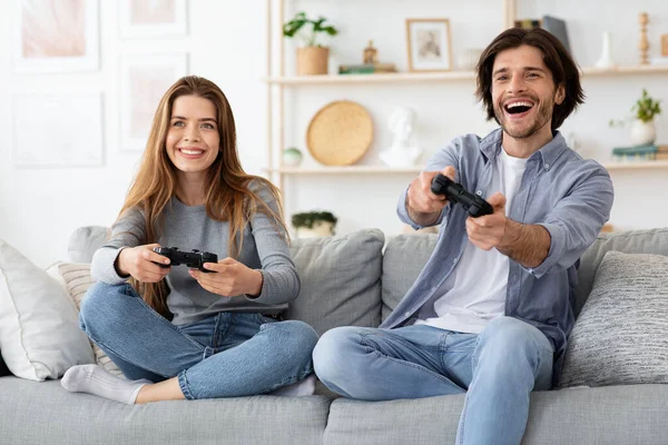 Συναισθηματική νεαρή οικογένεια που παίζει βιντεοπαιχνίδια στο σαλόνι — Φωτογραφία Αρχείου