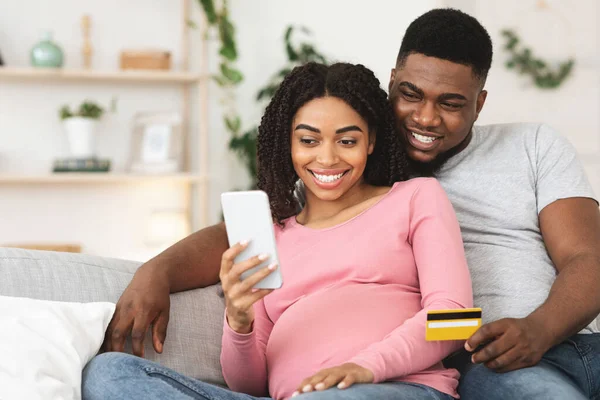 Šťastný těhotný pár pomocí mobilní aplikace pro nakupování — Stock fotografie