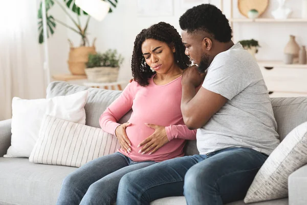 Внимательный африканский муж, поддерживающий беременную жену от боли. — стоковое фото