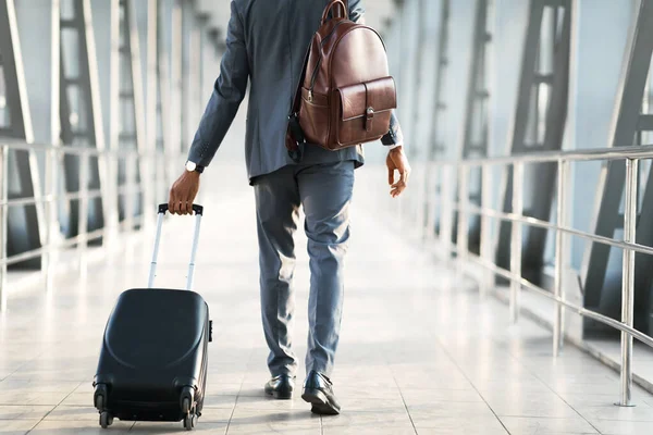 Hombre de negocios irreconocible caminando con equipaje en el aeropuerto interior, recortado — Foto de Stock