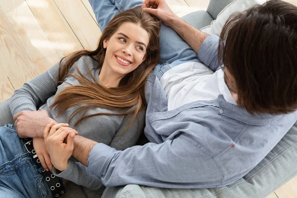 Couple cuddling at home, beautiful woman lying on man laps — Stock Photo, Image