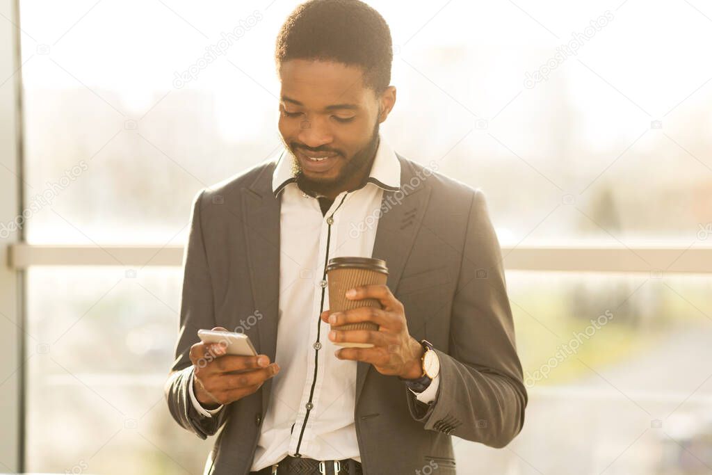 Businessman Using Phone Having Coffee Waiting For Flight In Airport