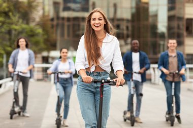 Elektrikli scooter kullanan mutlu öğrenciler.