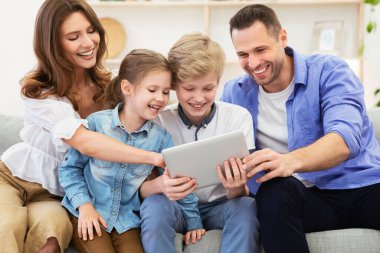 Aileler ve çocuklar tablet kullanıyor Evdeki koltukta oturuyorlar