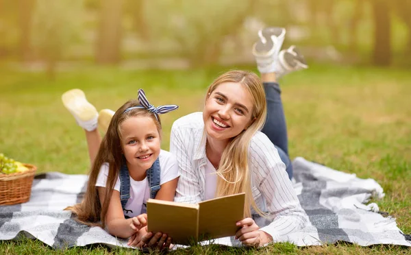 Mor och dotter Läsa bok Ligga på filt i parken — Stockfoto