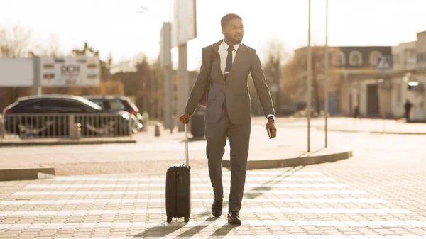 African Businessman With Travel Suitcase Crossing Road In City, Panorama — Stok Foto