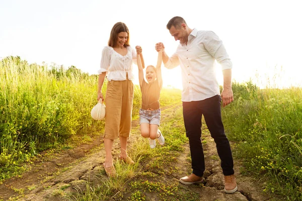 Gelukkig ouders en kind lopen samen in de zomer — Stockfoto