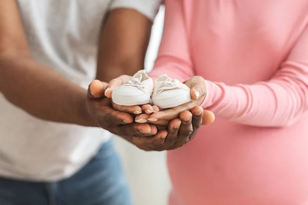 Attendre une famille afro-américaine tenant de petites chaussures de bébé — Photo