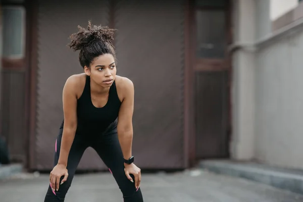 Descanse durante o treino ao ar livre. menina afro-americana com relaxamento rastreador de fitness de jogging — Fotografia de Stock