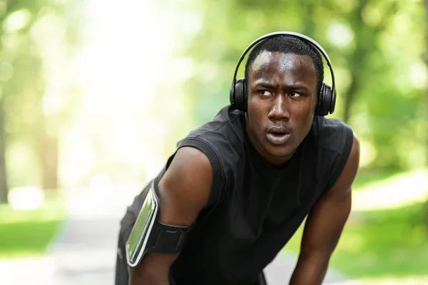 Müder afrikanischer Sportler macht Pause beim Training im Park — Stockfoto