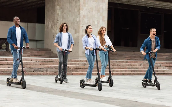 Cinco amigos teniendo agradable paseo en scooters motorizados — Foto de Stock