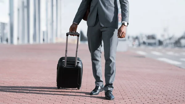 Bavullu tanınmayan girişimci açık hava havaalanı yakınlarında yürüyor, Kırpılmış, Panorama — Stok fotoğraf