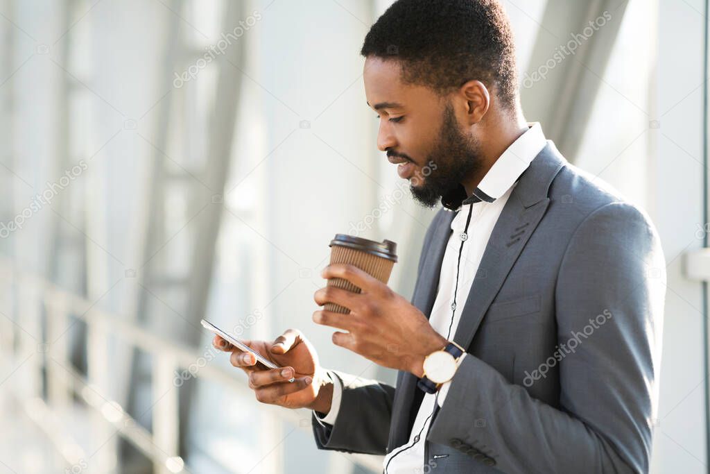 Happy African Businessman Using Cellphone Having Coffee In Airport Terminal