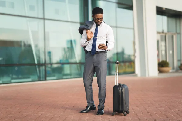 Siyah Girişimci Cep Telefonu Kullanıyor. Bavulları Havalimanında duruyor. — Stok fotoğraf
