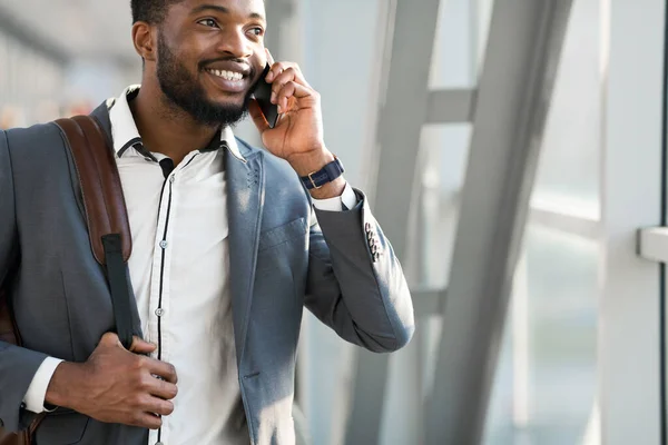 Empresario negro hablando por celular caminando en la terminal del aeropuerto, recortado — Foto de Stock